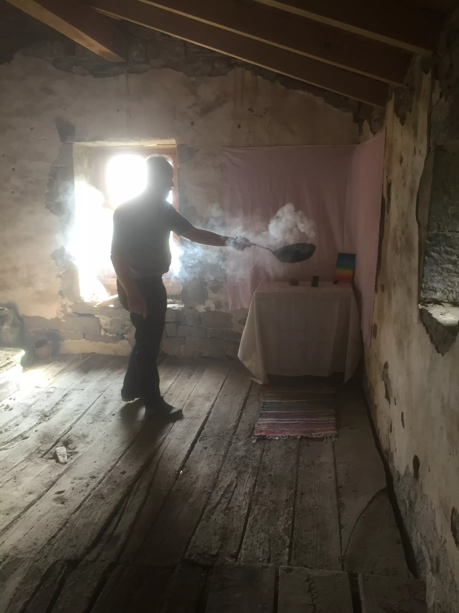Szene des Räucherns im Haus: intensives Auflegen des Räucherwerks für Schutz und Segen. Räuchern mit einer Gusseisen Pfanne