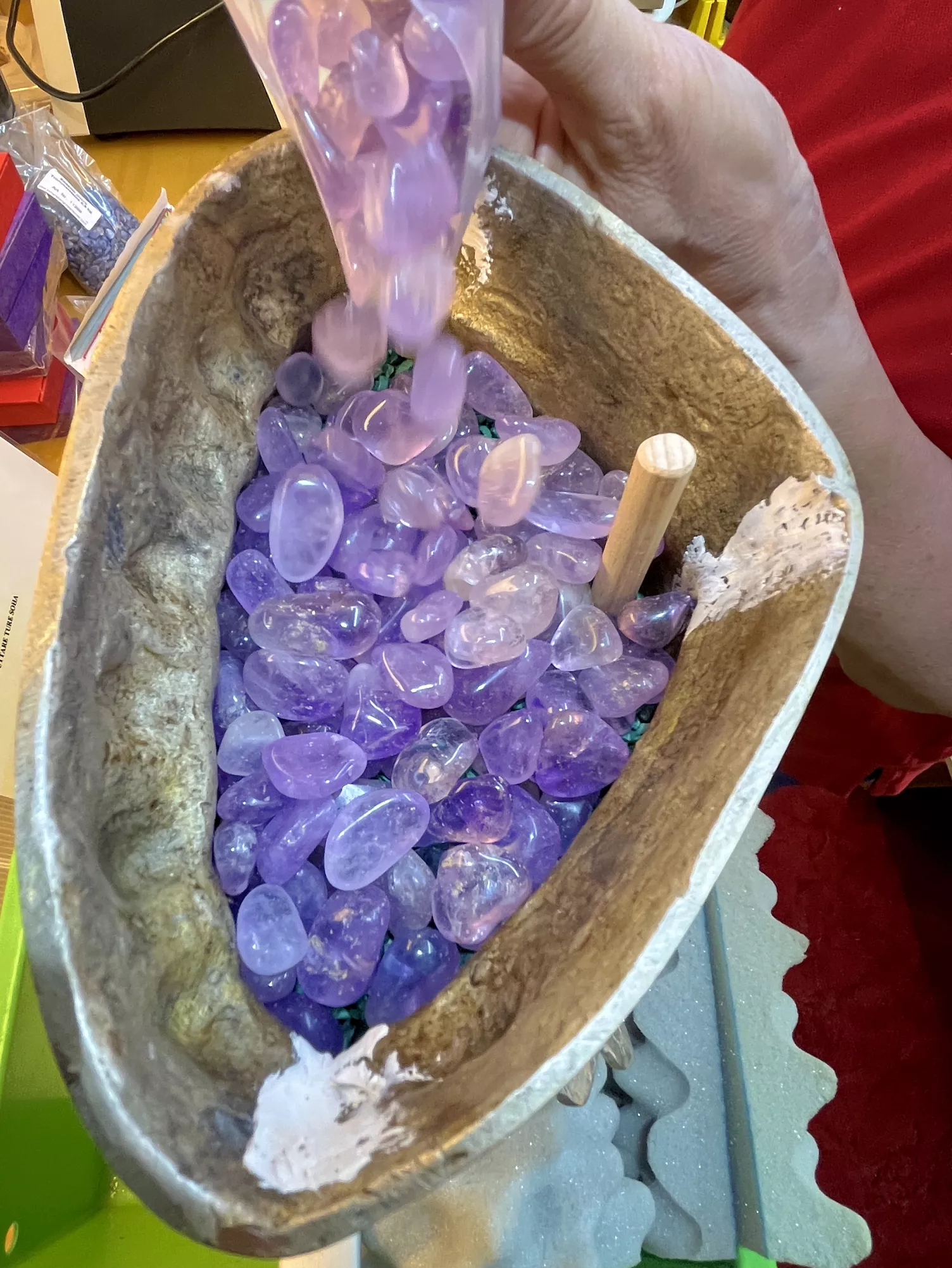 Kristalle werden achtsam in die Tara‑Statue eingelegt