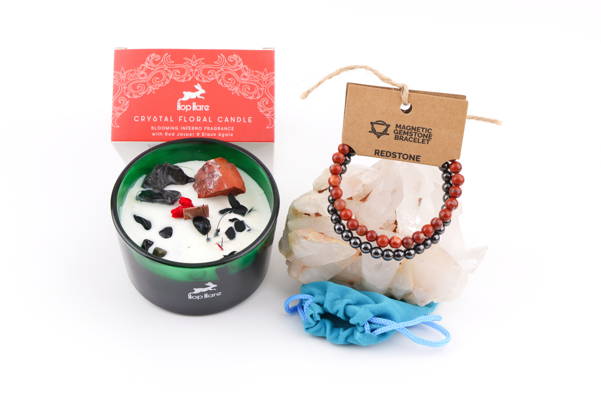 Eine Hop Hare Kerze im Karton mit Kristallen und Blüten, darauf die Tarotkarte „The Devil XV“; daneben ein Redstone‑Magnetarmband auf klaren Bergkristallen und ein kleiner türkisfarbener Stoffbeutel.
