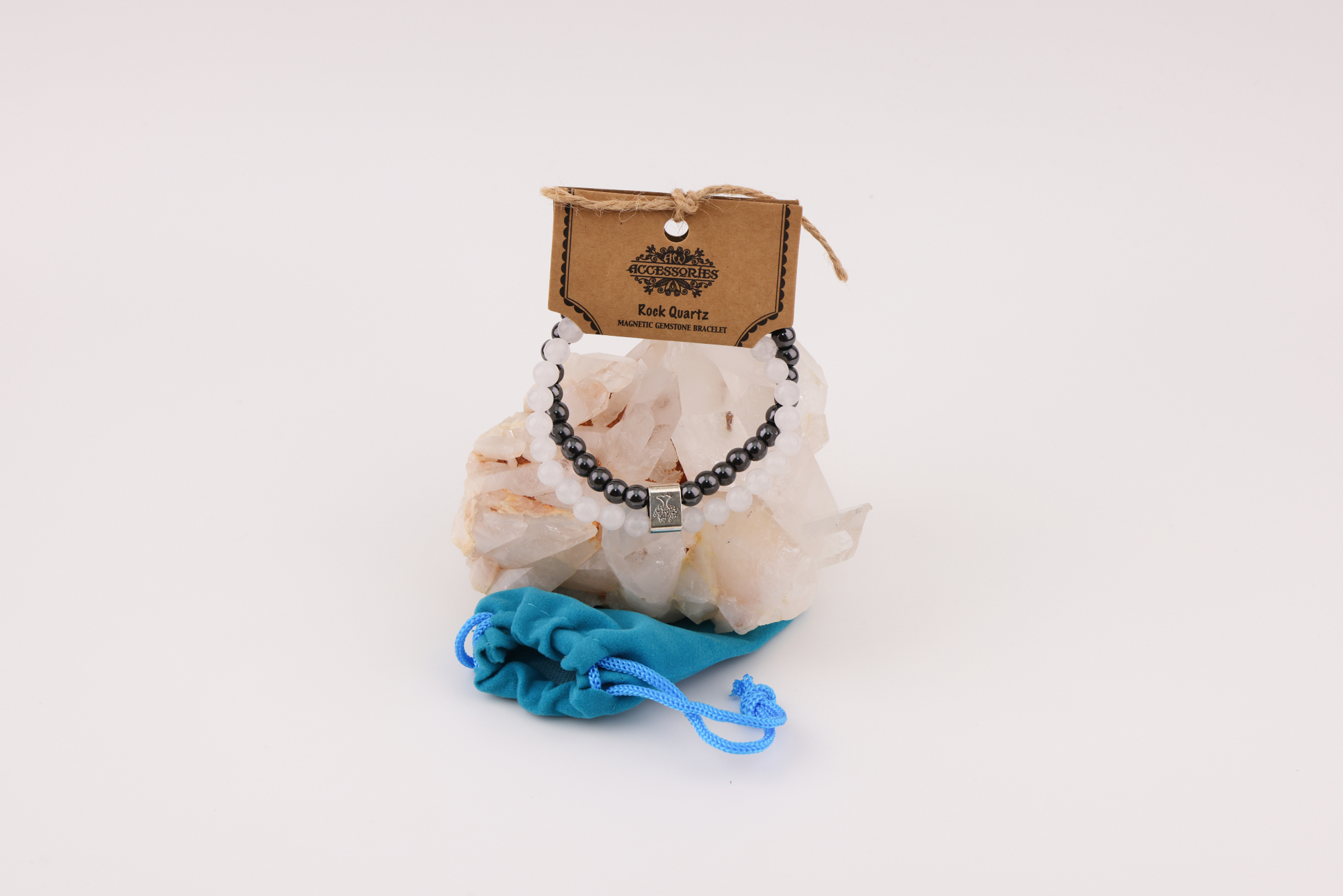 Schwarzes und weißes Magnetarmband auf Bergkristall mit blauem Schmuckbeutel.