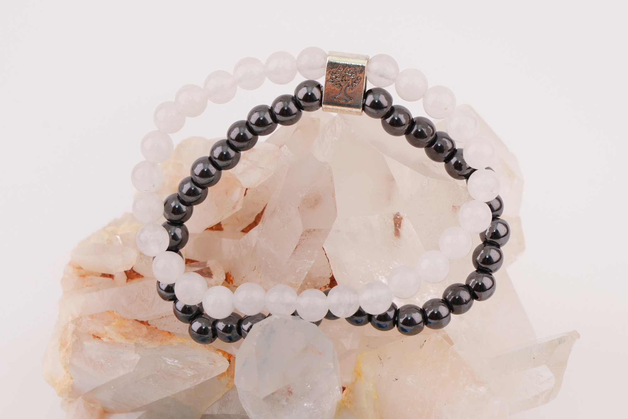Schwarzes und weißes Magnetarmband auf Bergkristall mit blauem Schmuckbeutel.