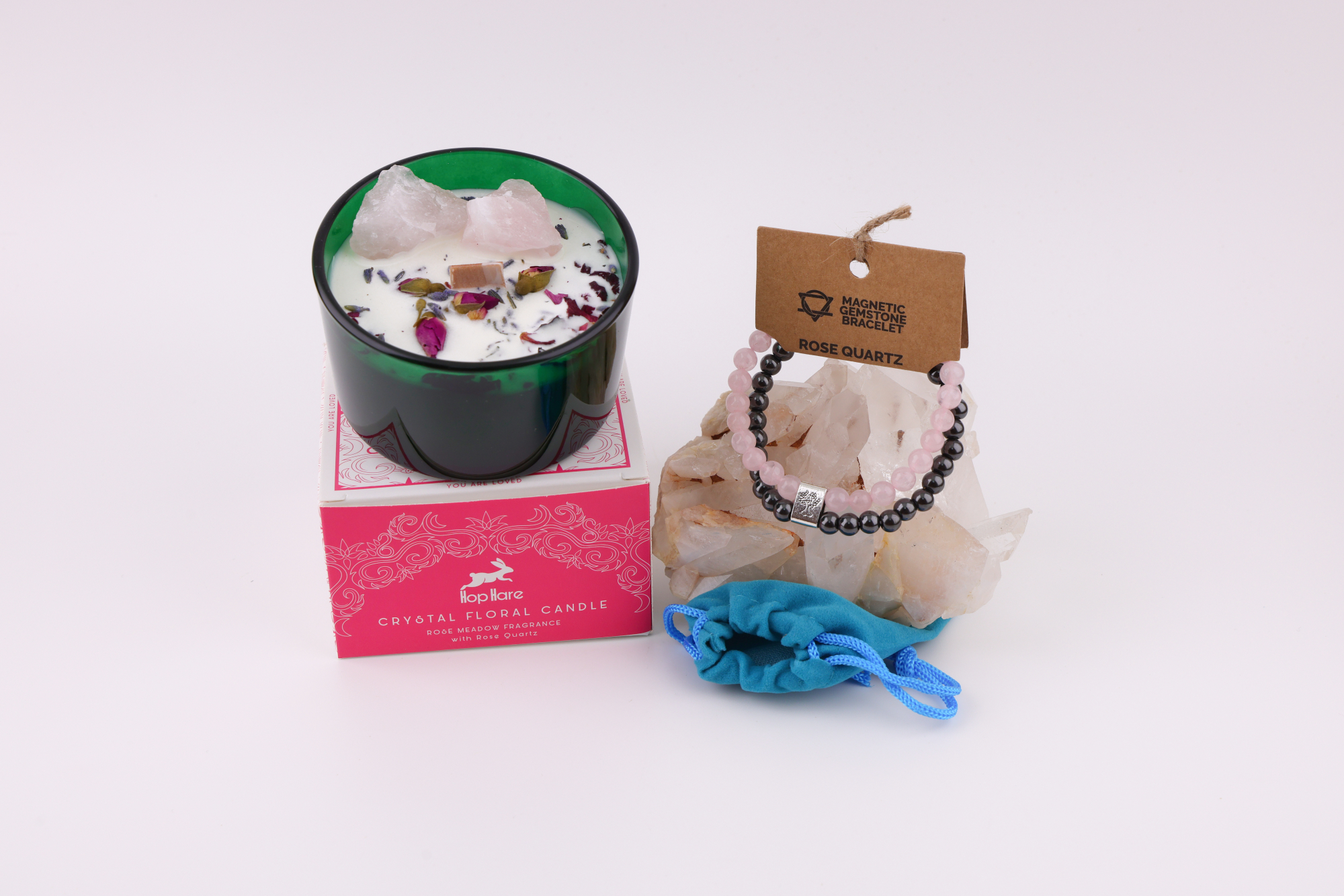 Hop‑Hare‑Kerze Die Liebenden mit Rosenquarz und Rosenquarz‑Magnetarmband auf Bergkristall.