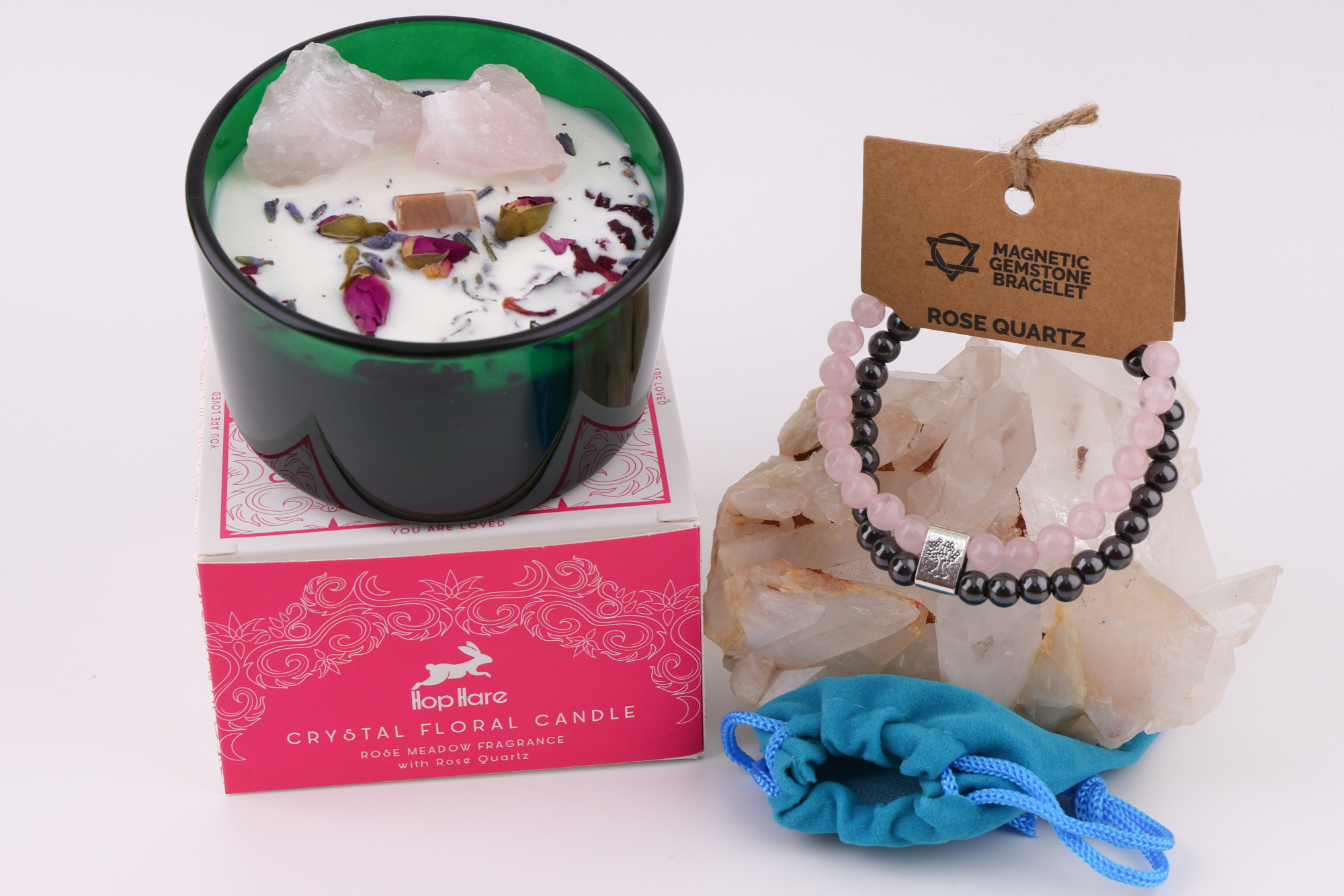 Hop‑Hare‑Kerze Die Liebenden mit Rosenquarz und Rosenquarz‑Magnetarmband auf Bergkristall.