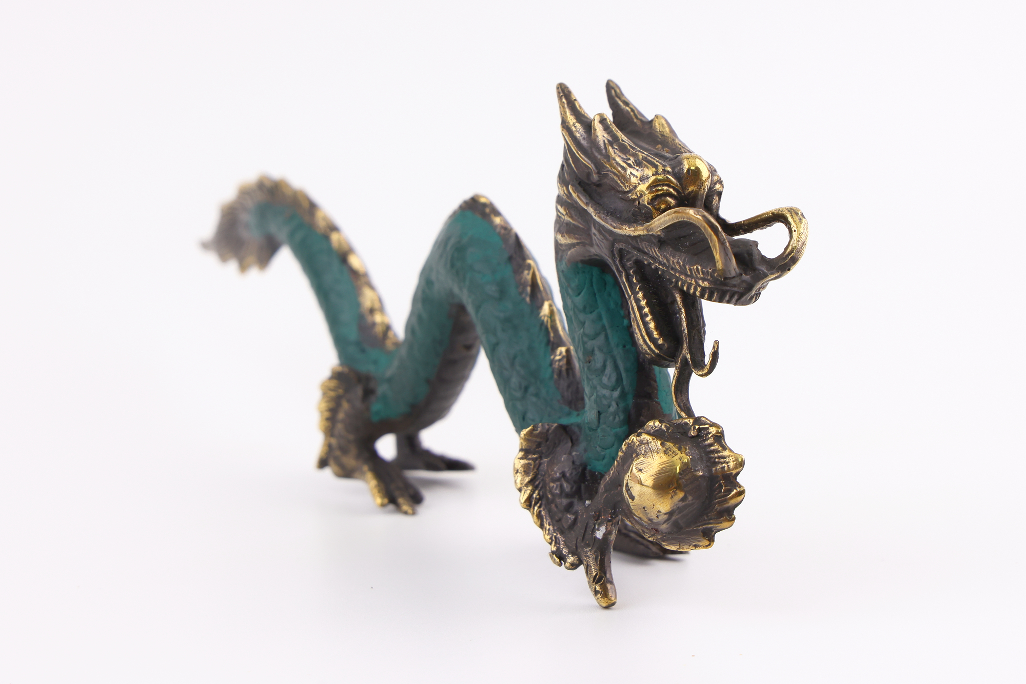 Grün-goldene Messing‑Drachenfigur mit langem geschwungenem Körper, geöffnetem Maul und goldener Energiekugel in der Klaue.