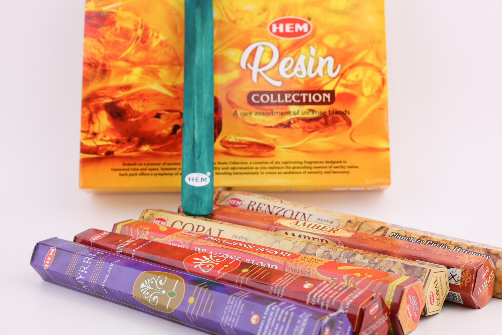 HEM Räucherwerk‑Set mit großer Resin Collection Box im Hintergrund sowie mehreren Duftstäbchen‑Packungen (Myrrh, Dragon’s Blood, Copal, Benzoin, Amber) und einem türkisfarbenen Räucherstäbchenhalter im Vordergrund.