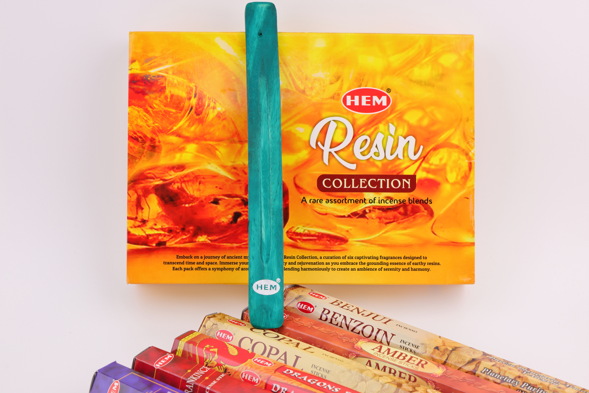 HEM Räucherwerk‑Set mit großer Resin Collection Box im Hintergrund sowie mehreren Duftstäbchen‑Packungen (Myrrh, Dragon’s Blood, Copal, Benzoin, Amber) und einem türkisfarbenen Räucherstäbchenhalter im Vordergrund.