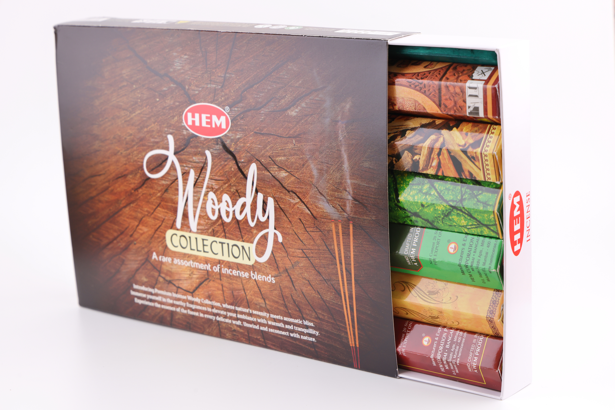 HEM Räucherwerk‑Set der Woody Collection mit verschiedenen Duftstäbchen‑Packungen (Cedar, Palo Santo, Foret, Feng Shui, Sandal), gelben Räucherstäbchen und grünem Halter.